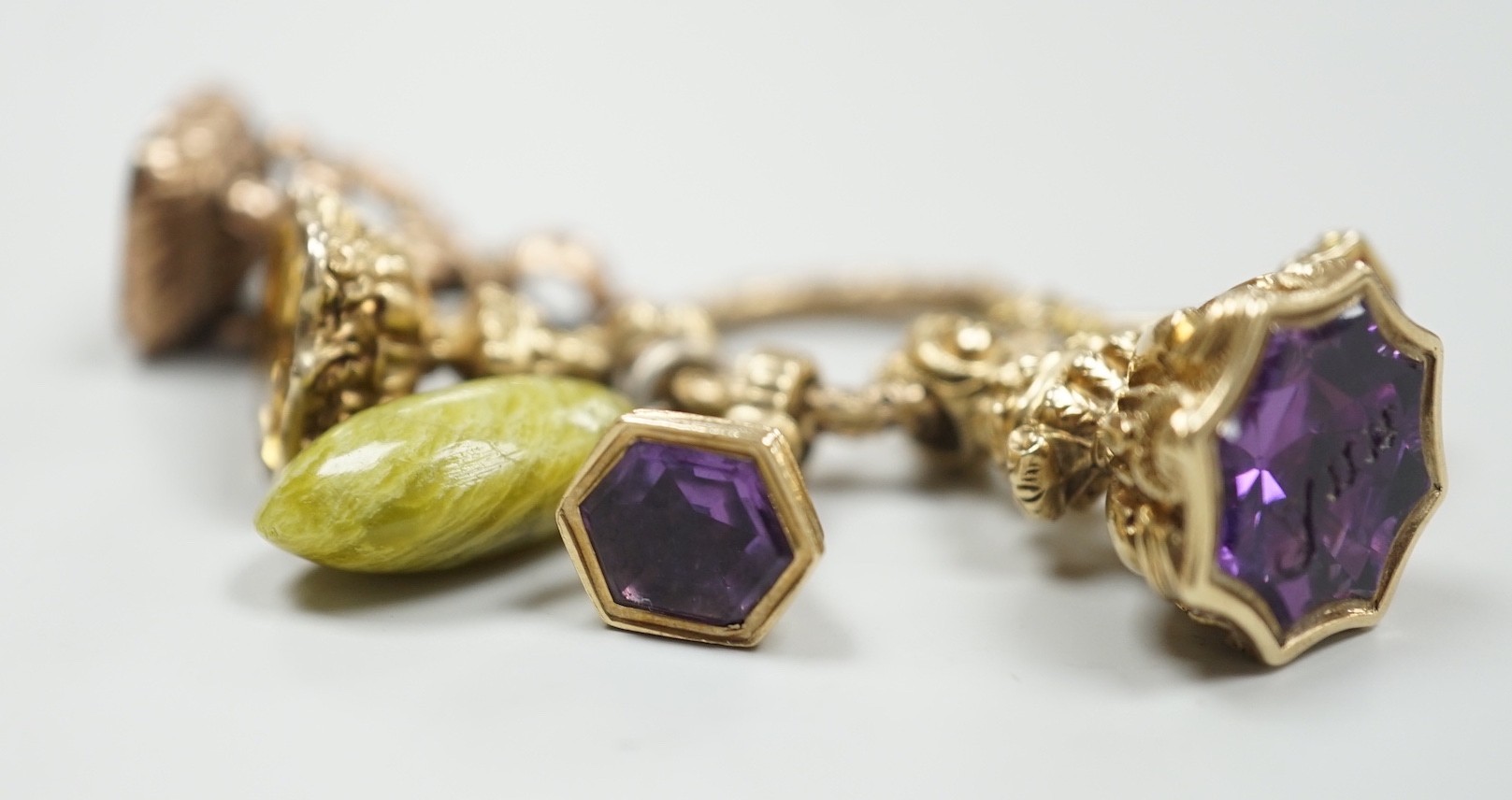 Four Victorian assorted yellow metal and gem set fob seals, including two amethyst(one carved with initials), one citrine and one carnelian (carved with monogram), together with a stone? charm and a gold plate mounted ci